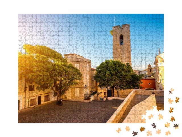 Puzzle de 1000 pièces « Place centrale avec tour et église dans le village côtier d'Antibes sur la Côte d'Azur en France »