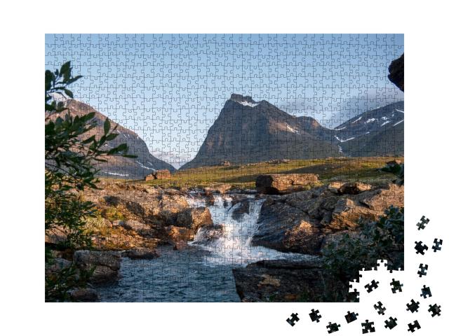 Puzzle de 1000 pièces « Tuolpagorni, montagne culte en Suède derrière une chute d'eau »