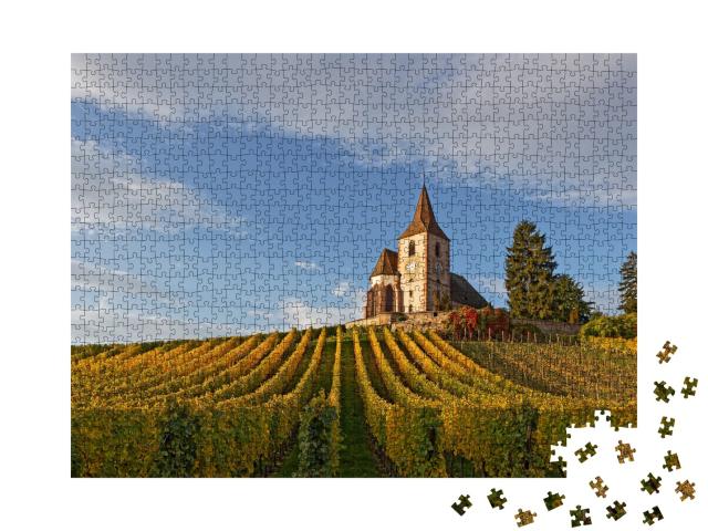 Puzzle de 1000 pièces « Église du village alsacien de Hunawihr, entourée de vignobles, avec de belles couleurs jaunes d'automne »